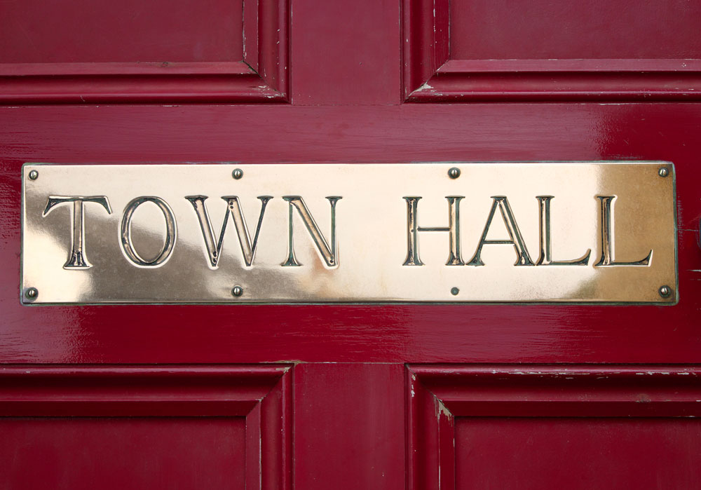 Red door with gold engraved Town Hall plate for business signage
