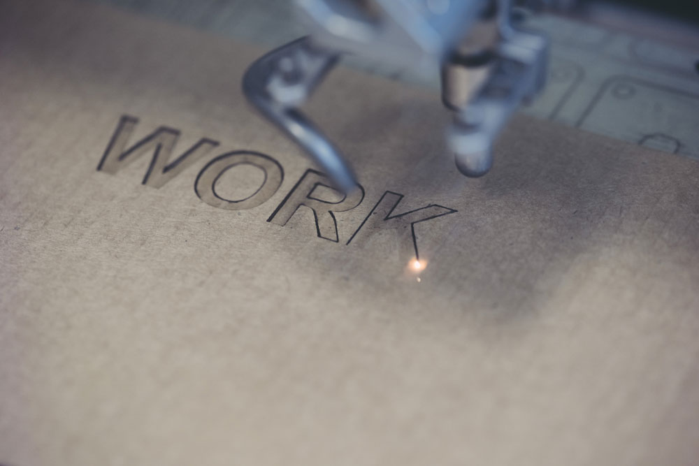 Metal piece engraved with WORK text using custom engraving